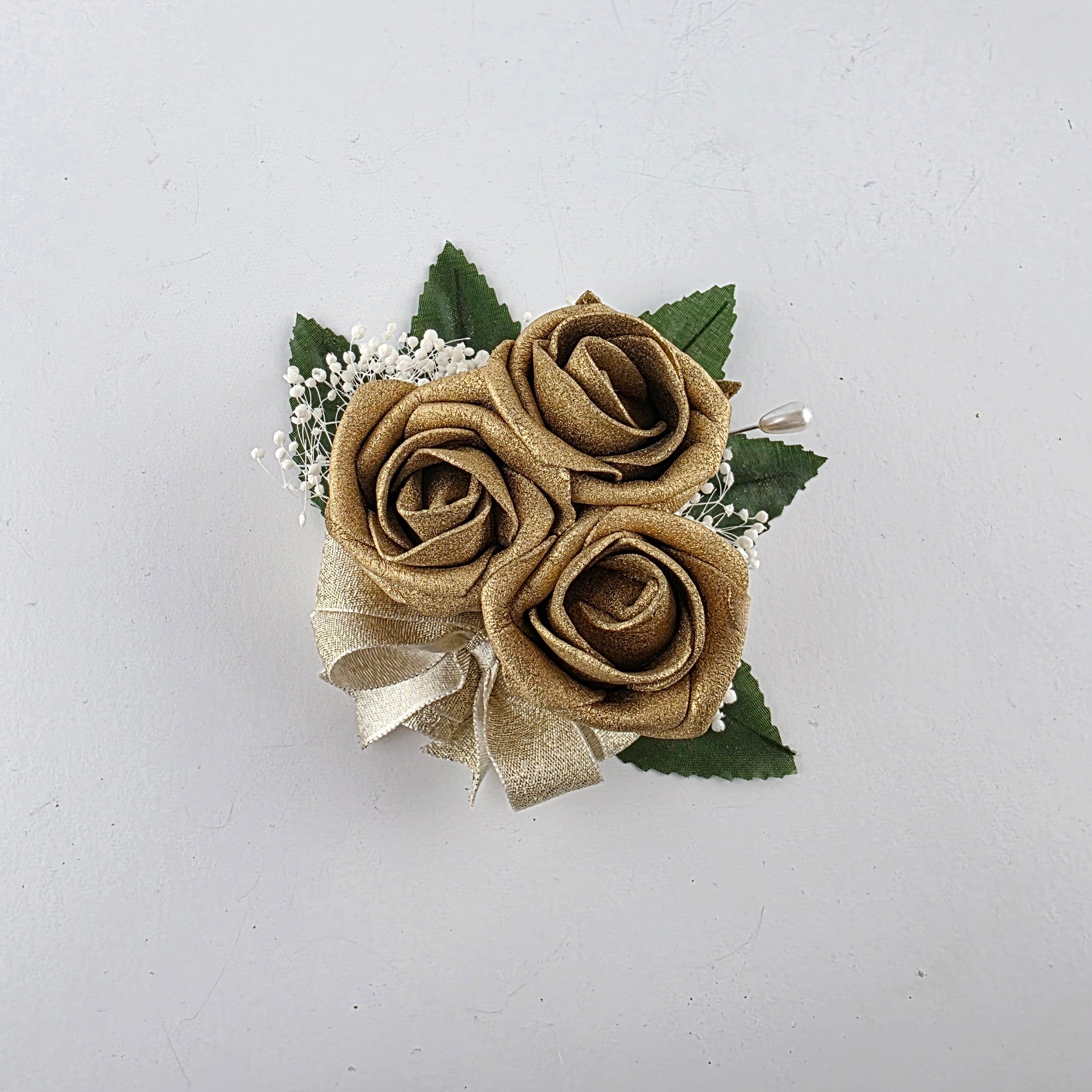 All gold pin on corsage with baby's breath