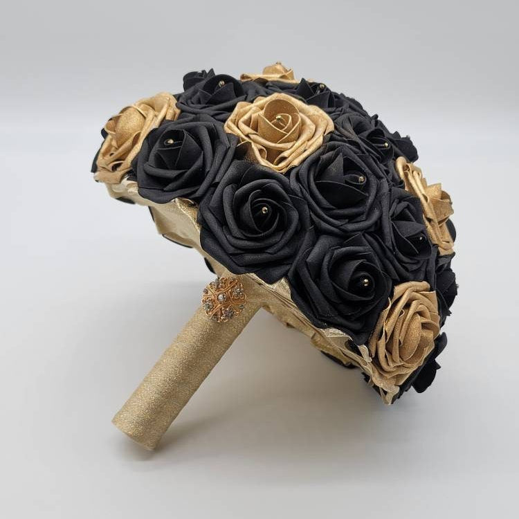 Black and gold bouquet with rhinestones on every rose. handle is made up of gold ribbon and finished with gold brooch.