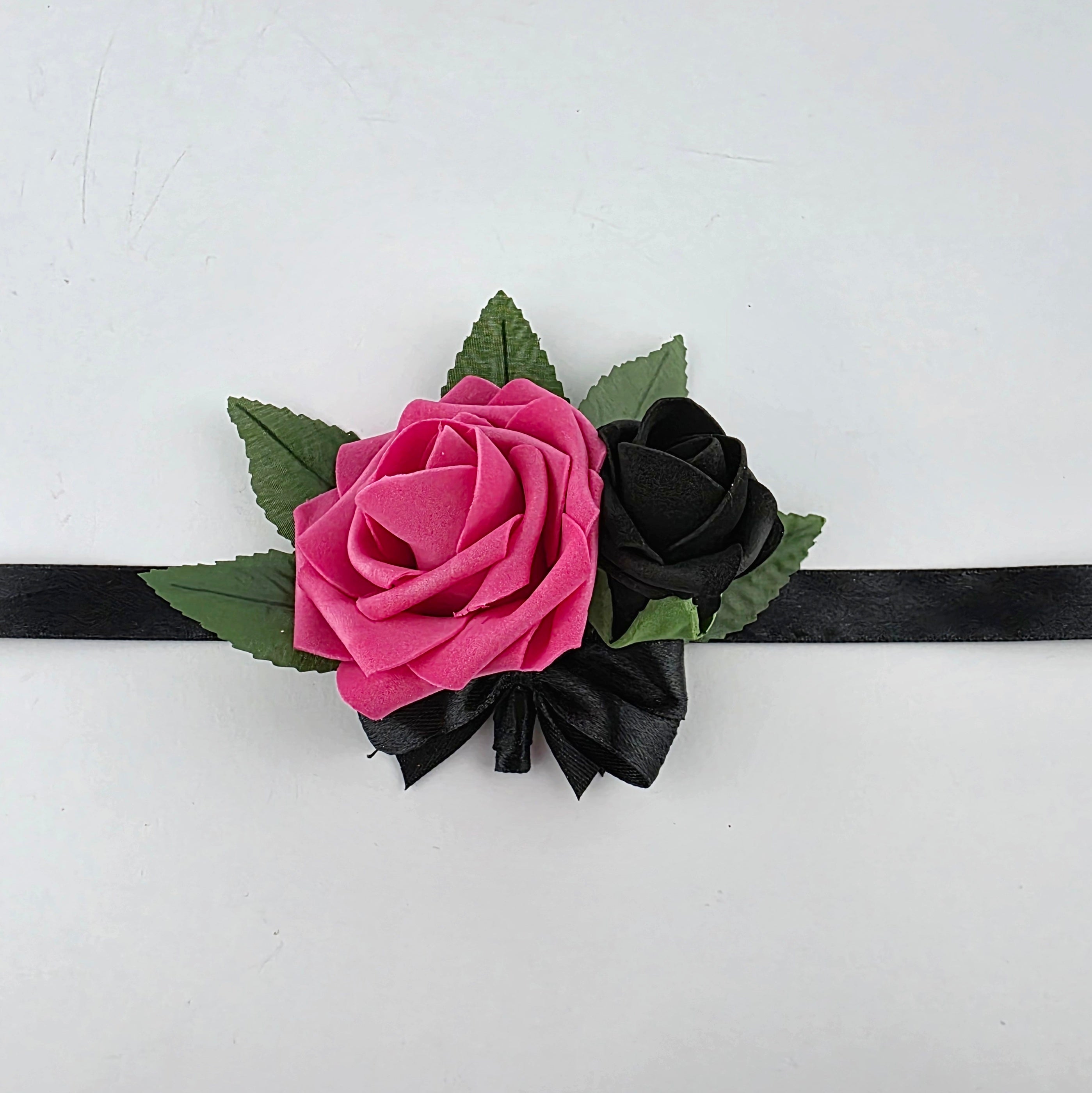 Hot pink and black wrist corsage with 5 leaves and black satin wrist band