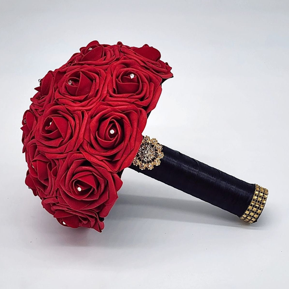 Red Real Touch Roses Wedding Bouquet with Black Satin Ribbon handle. Handle is finished with a gold brooch and gold bling wrap. Rhinestones are on every rose. Great for brides, bridesmaids, prom, homecoming, and Quinceanera.