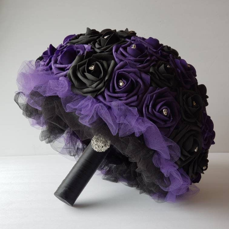 Black and purple roses with skulls on every rose. Handle is made up of purple and black tulle, black satin ribbon and finished with silver brooch.