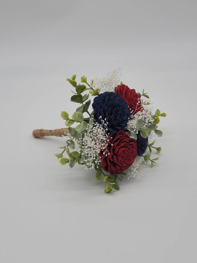 Burgundy and navy sola wood flowers with eucalyptus greenery and baby&#39;s breath. Handle is wrapped in twine.