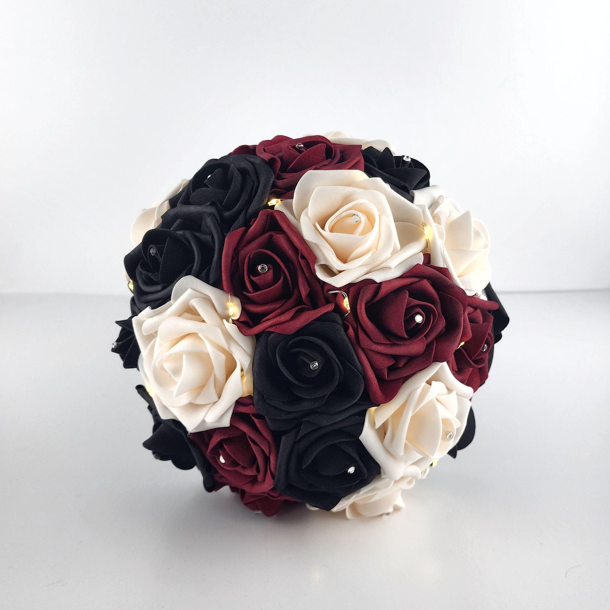 Black, Burgundy, and Cream Fairylight bouquet- Wedding bouquet-Bouquet is made using real touch roses. Handle is Blackwith a Burgundy French twist and finished with silver bling wrap. Fairy Lightsare strung through bouquet