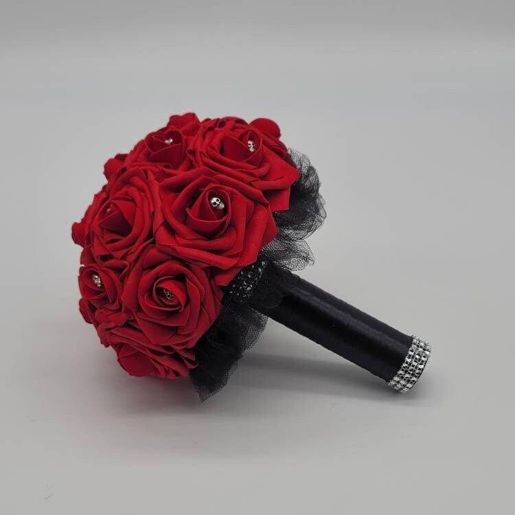 Red gothic skull wedding bouquet. Silver skulls are on every rose. Handle is made up of black tulle and black satin ribbon, finished with silver bling wrap.